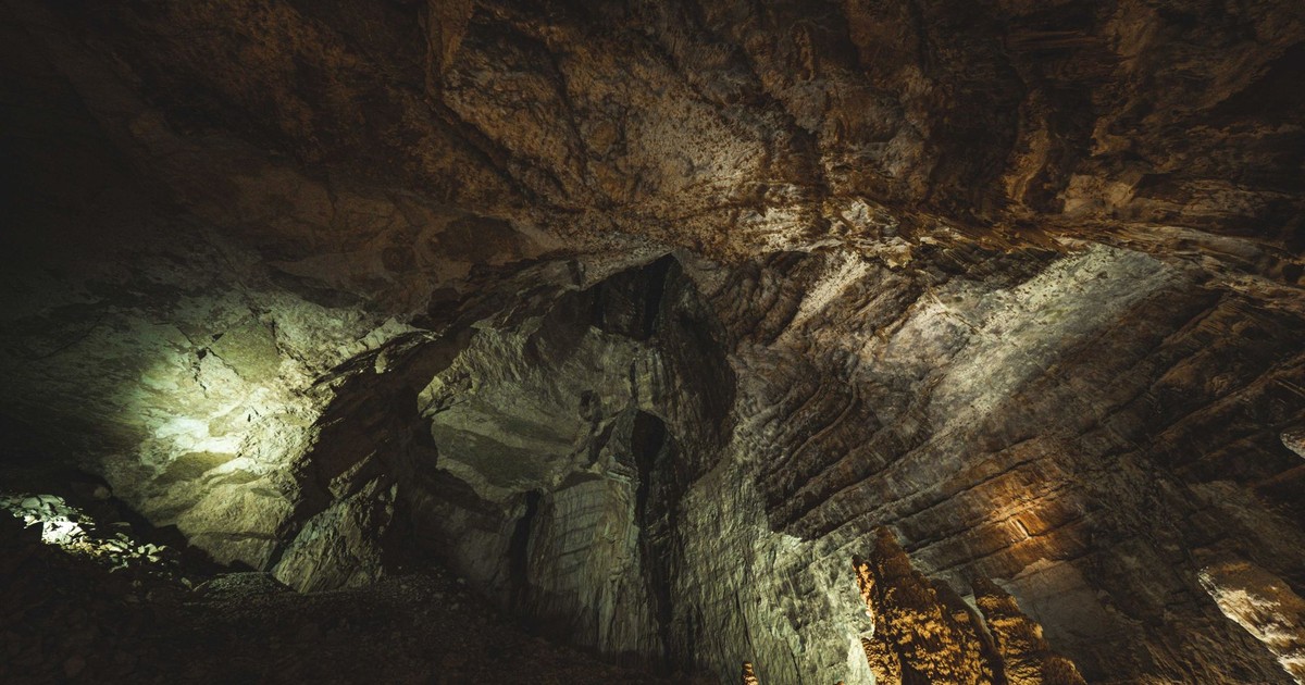Explore the depth and textures of a dramatic underground cave with intricate rock formations.