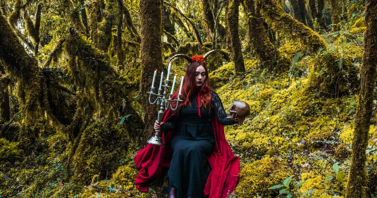 A mystical forest witch holding a candelabra and skull in Choachí, Colombia.