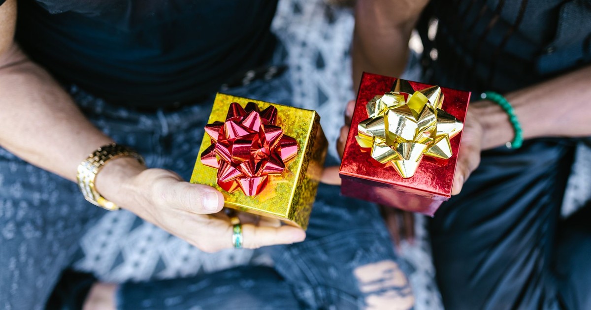 Two people holding beautifully wrapped gift boxes with bows, perfect for celebrations.