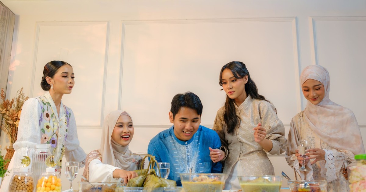 A cheerful family enjoying a traditional Eid meal together in Jakarta, Indonesia.