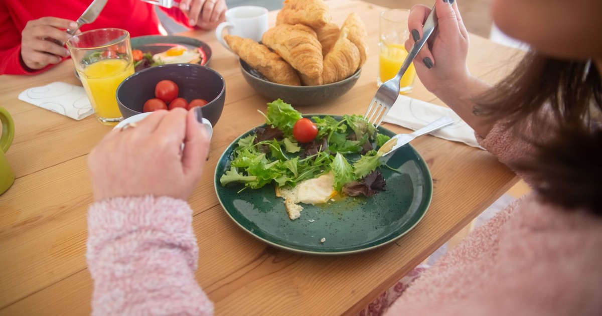 Cozy breakfast scene with fresh salad, croissants, and juice, perfect for a healthy morning.