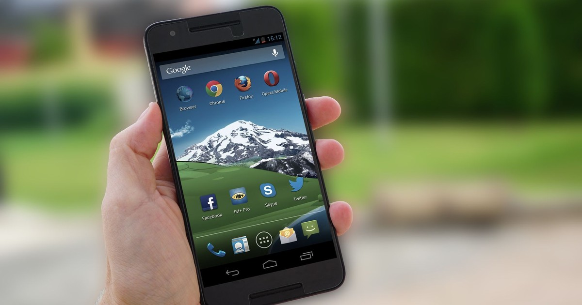 Close-up of a smartphone in hand displaying social media apps on screen.
