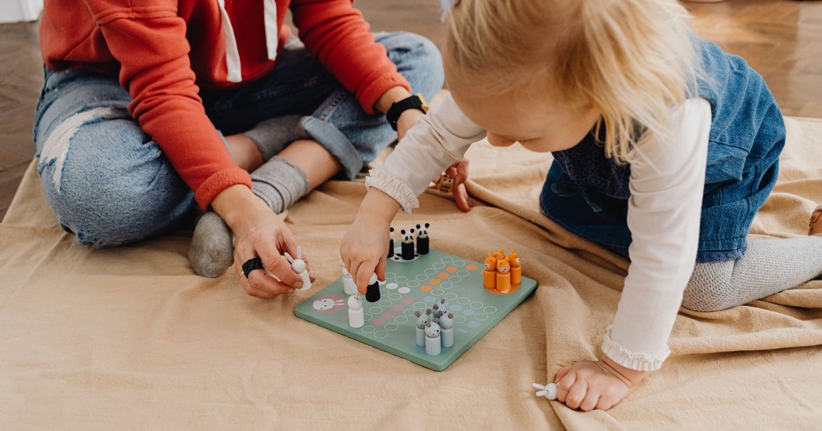 A mother and daughter bonding over a board game indoors, capturing family fun and togetherness.