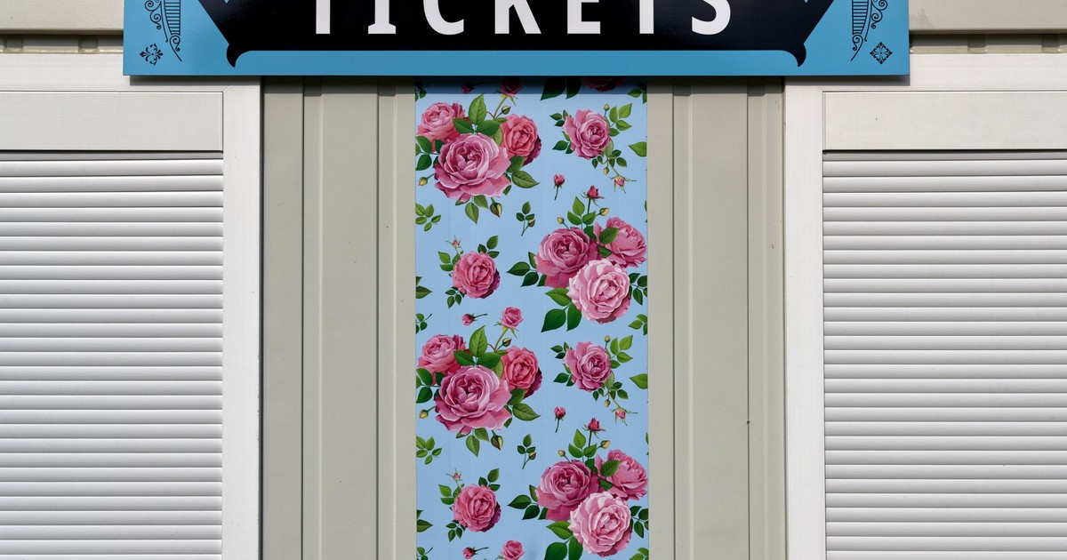 A vibrant ticket booth exterior with floral patterns and bold signage.