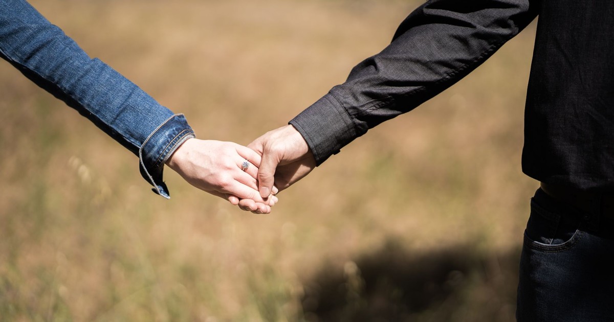 Two people holding hands in a romantic outdoor setting in Sacramento.