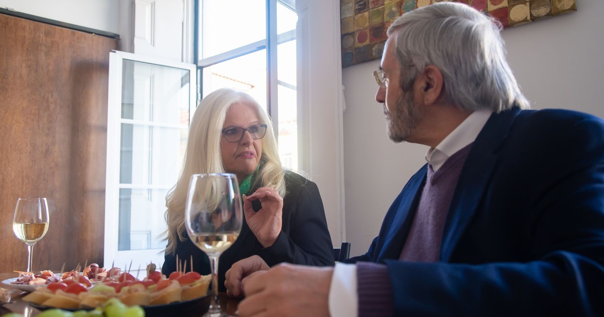 Senior couple enjoying a sophisticated meal with wine in a Portuguese restaurant.