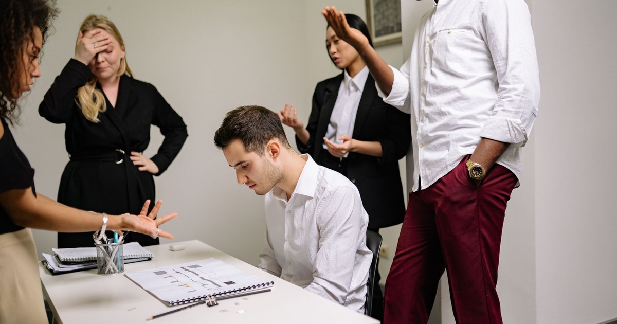 Business professionals engaged in a tense discussion at the office, highlighting workplace conflict.