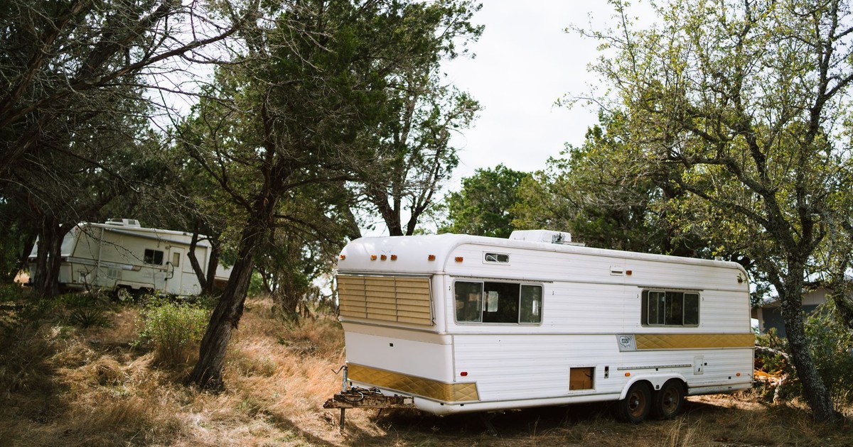 Vintage camper trailers set amidst trees in a peaceful Texas forest scene.
