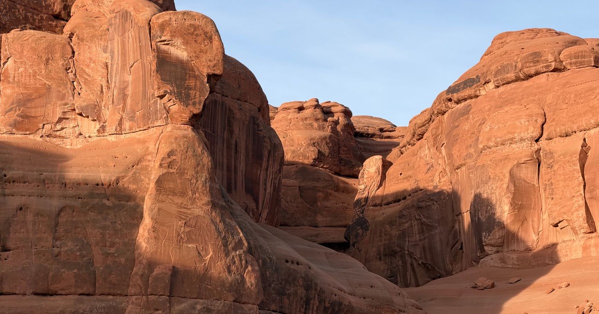 Stunning view of sandstone cliffs with a clear blue sky, showcasing natural desert beauty.