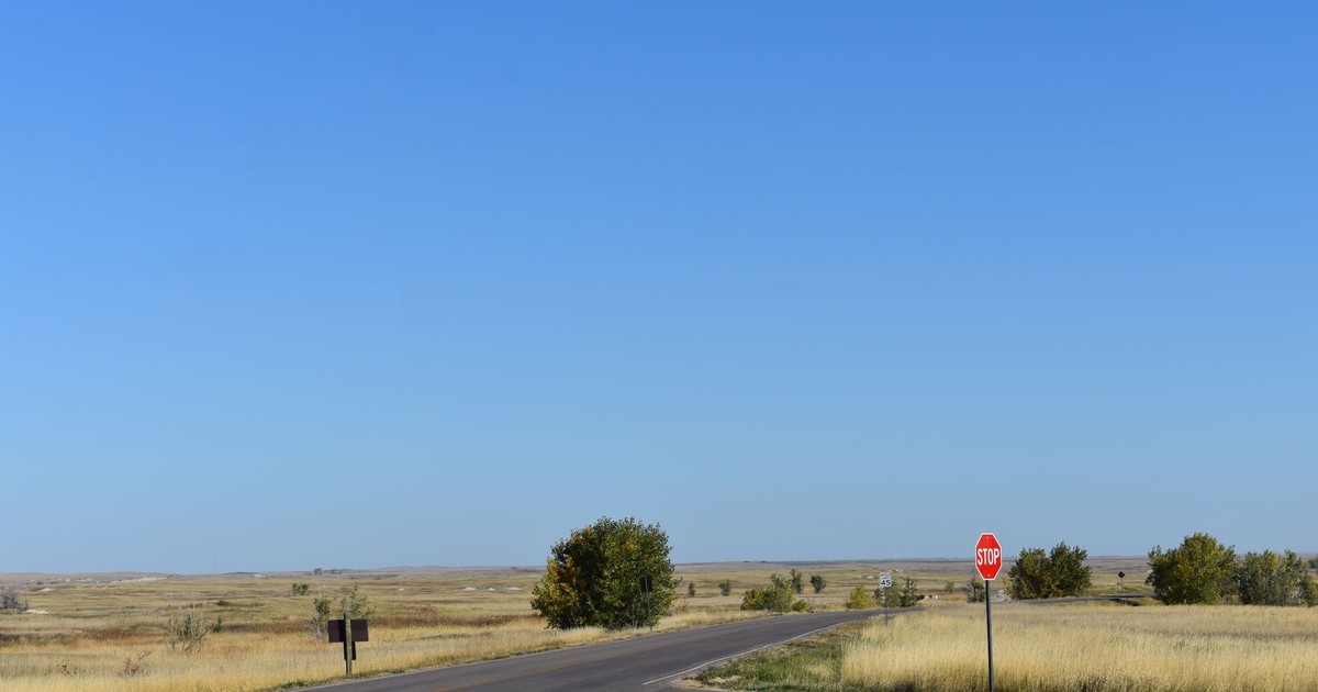 Quiet rural road intersection with a stop sign in South Dakota's open plains.