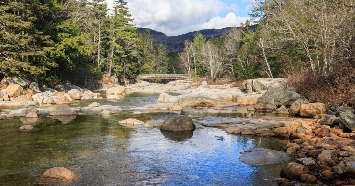 Tranquil river scene with rocks and forest in Albany, New Hampshire, USA.