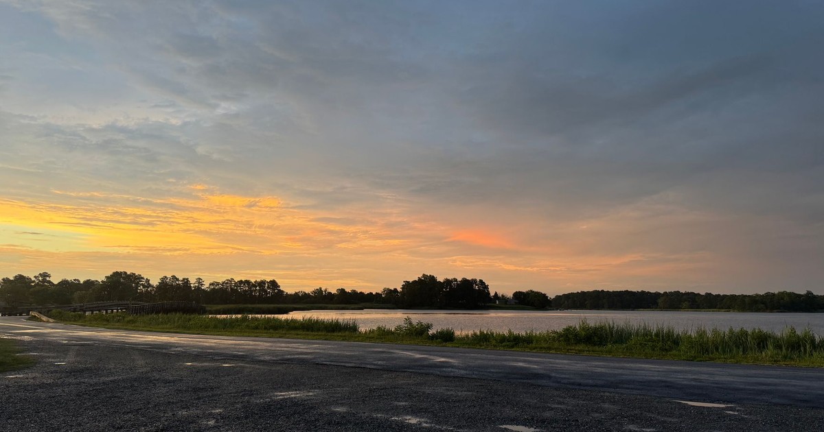 Serene summer sunset over tranquil waters in Rock Hall, Maryland, with vibrant pastel skies.