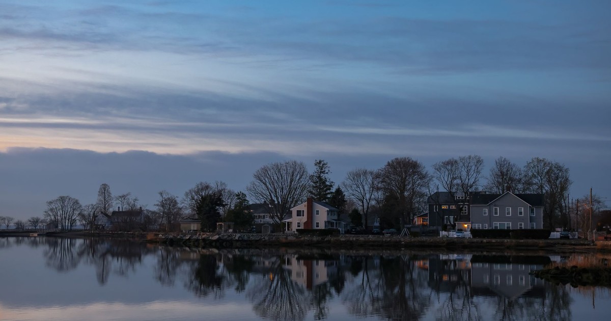 Peaceful evening view of houses reflecting on water in Stamford, Connecticut.