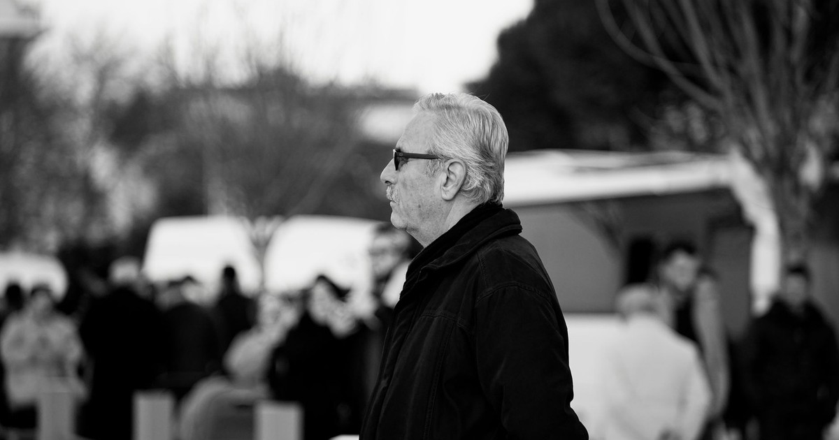 Black and white photo of an elderly man in sunglasses outdoors, emphasizing solitude.