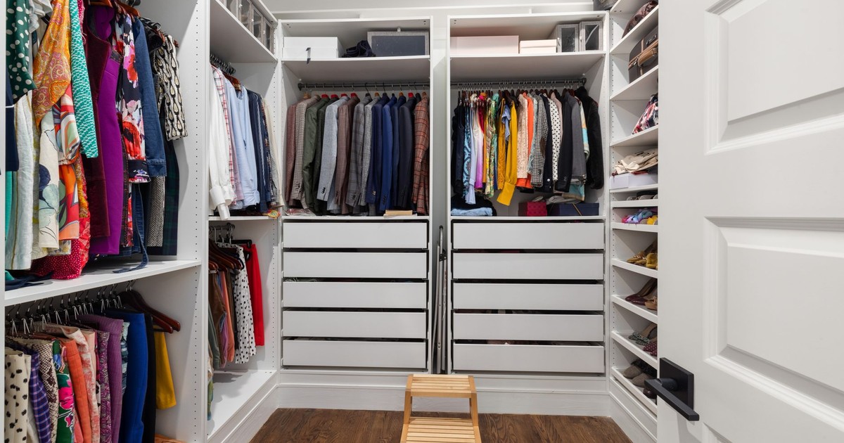A neatly arranged walk-in closet showcasing a colorful variety of clothes and shoes.