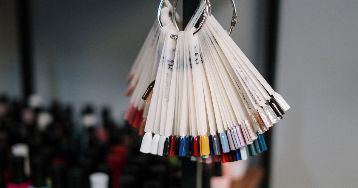 A vibrant display of nail polish swatches hanging in a beauty salon, showcasing diverse color options for manicure trends.