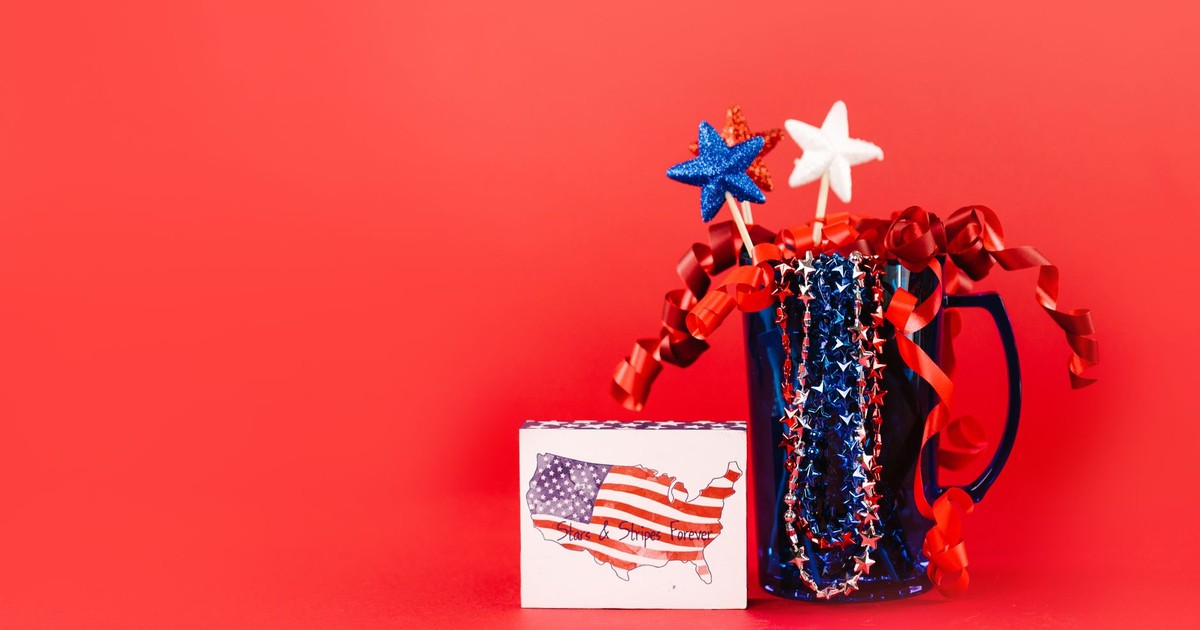 A festive display of red, white, and blue patriotic decor against a vibrant red background, perfect for July 4th celebrations.