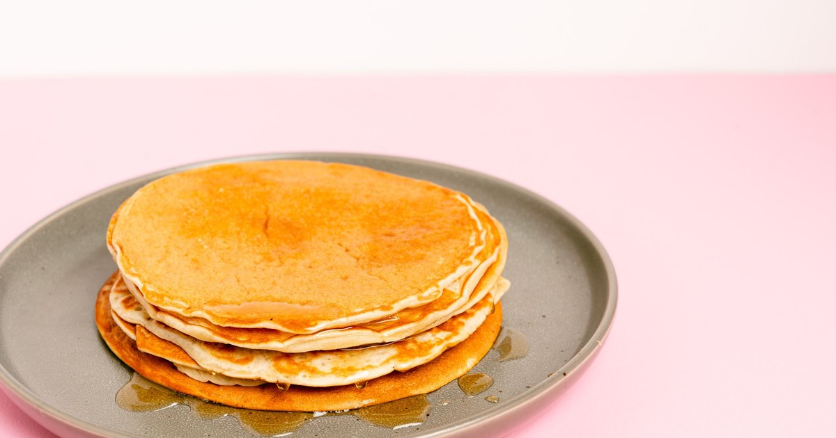Close-up of pancakes stacked on a plate with syrup, perfect for breakfast themes.