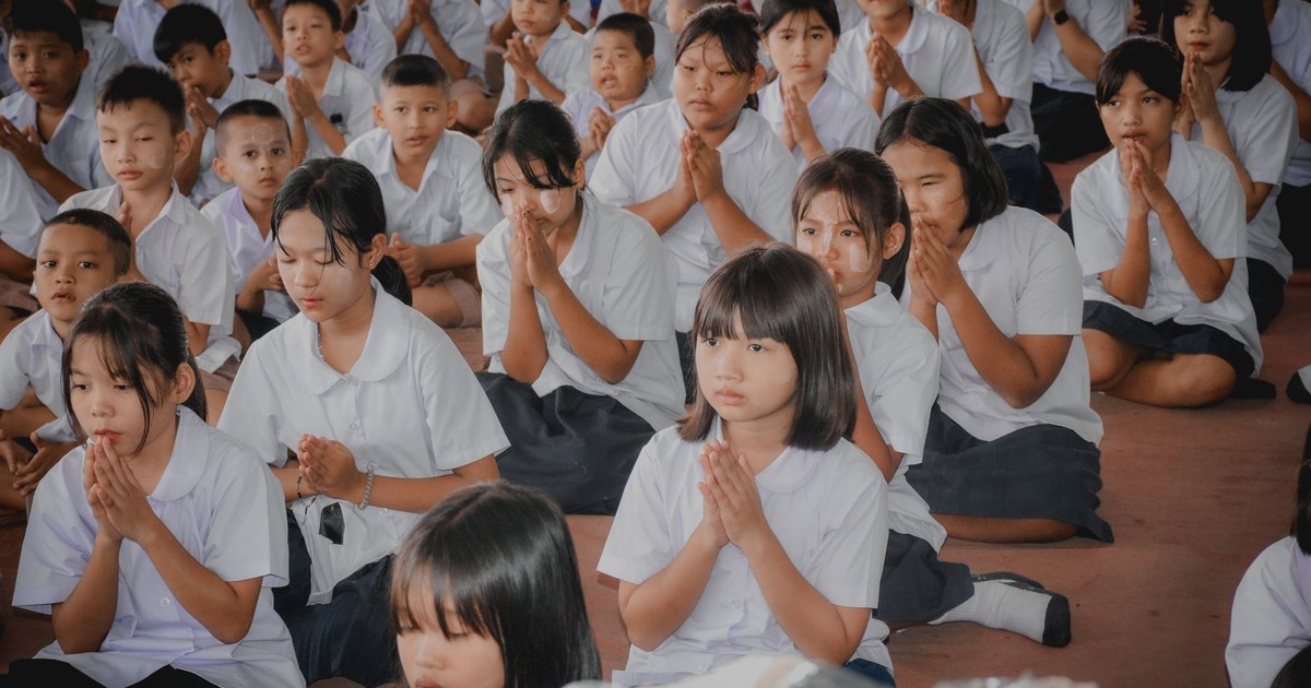 Students in uniform meditating at a school assembly, focused and serene.