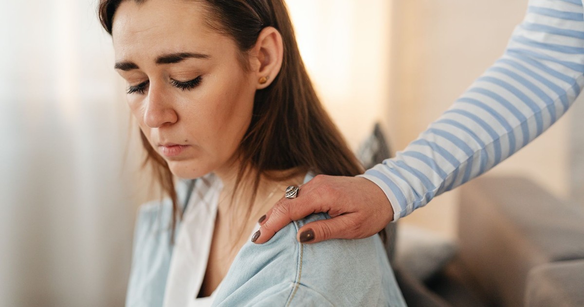 A comforting hand on a woman's shoulder, showcasing empathy and support.