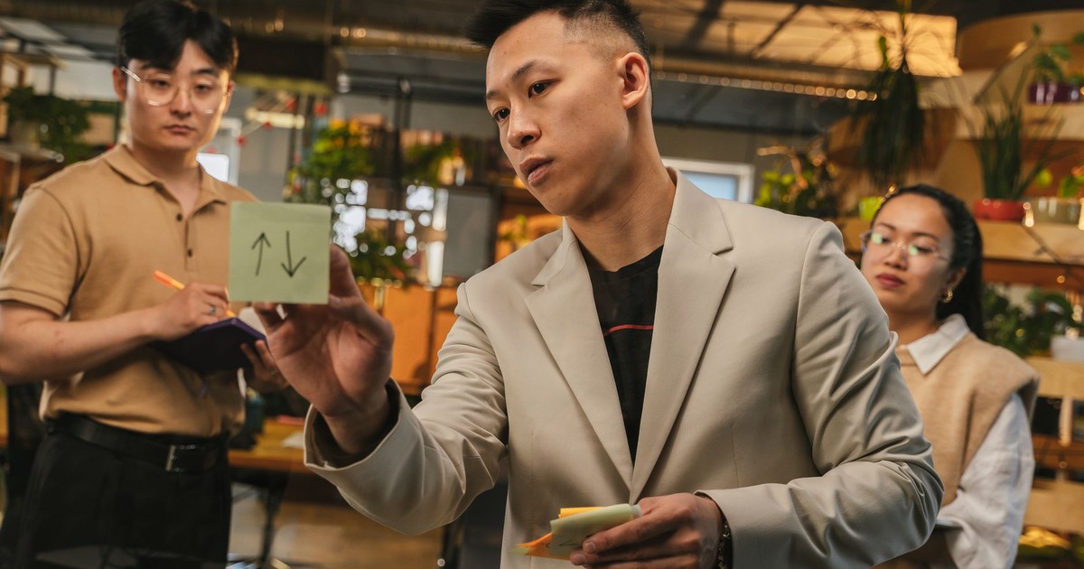 Team brainstorming ideas with sticky notes in a modern office setting.