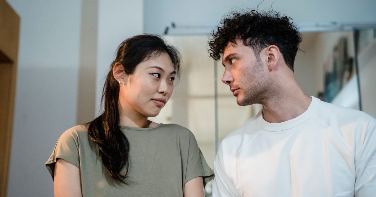 A couple looking at each other lovingly in a cozy indoor setting, highlighting a moment of connection.