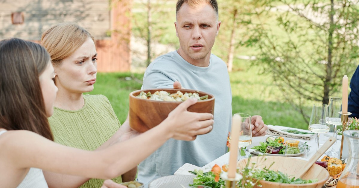 A family sharing a meal outdoors, showcasing togetherness and nature.