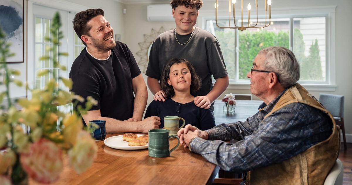 A family of four sharing a joyful moment in the kitchen, bonding over food and conversation.