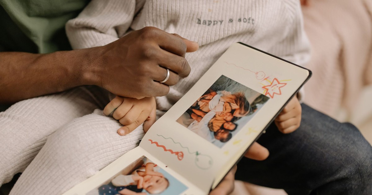 A father and child share a touching moment revisiting cherished family memories in a photo album.