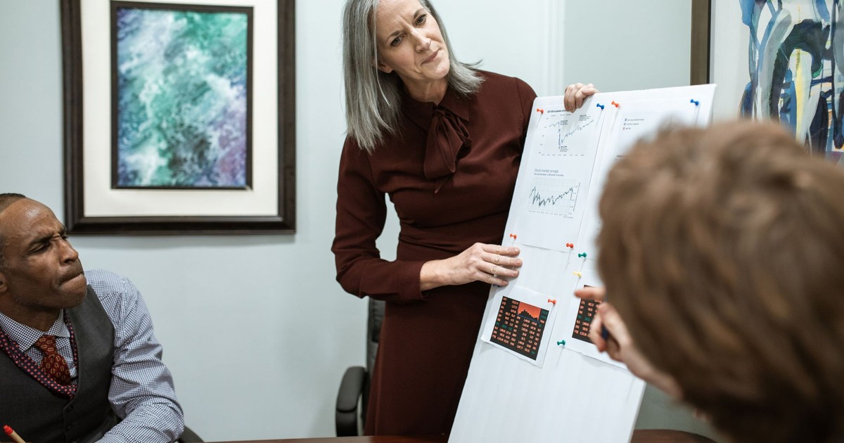 Businesswoman presenting data in a conference room meeting with colleagues.