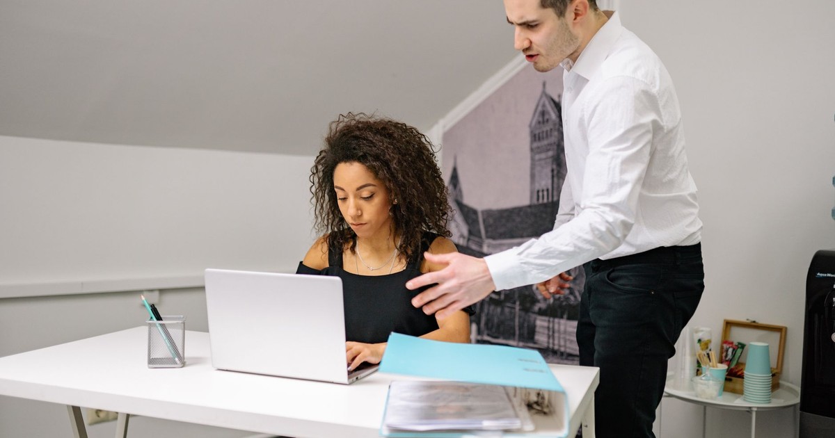 Manager and employee in discussion at the office, highlighting workplace dynamics.