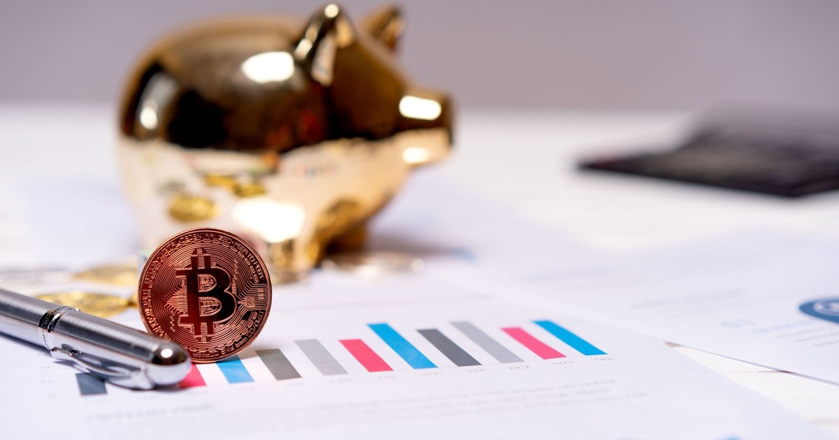 A Bitcoin coin on financial charts with a gold piggy bank, symbolizing modern finance.
