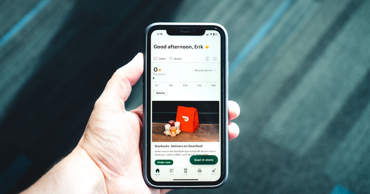 Close-up of a smartphone with a delivery app interface in a person's hand, emphasizing modern e-commerce.