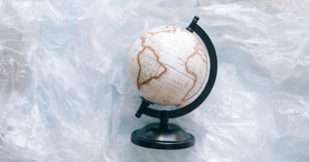 A globe wrapped in plastic symbolizes environmental issues and the need for sustainability.