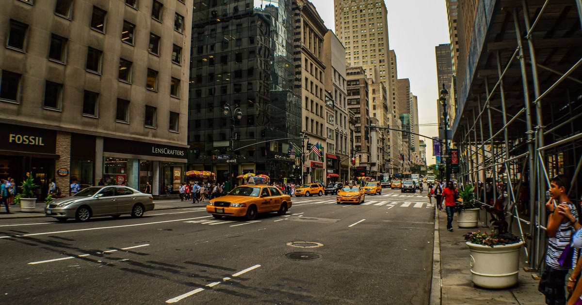A lively street view of Midtown Manhattan capturing iconic yellow taxis and tall buildings.