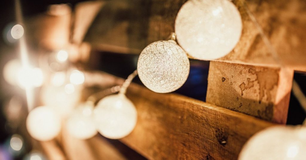 Cozy and warm atmosphere created by string lights against a wooden backdrop.