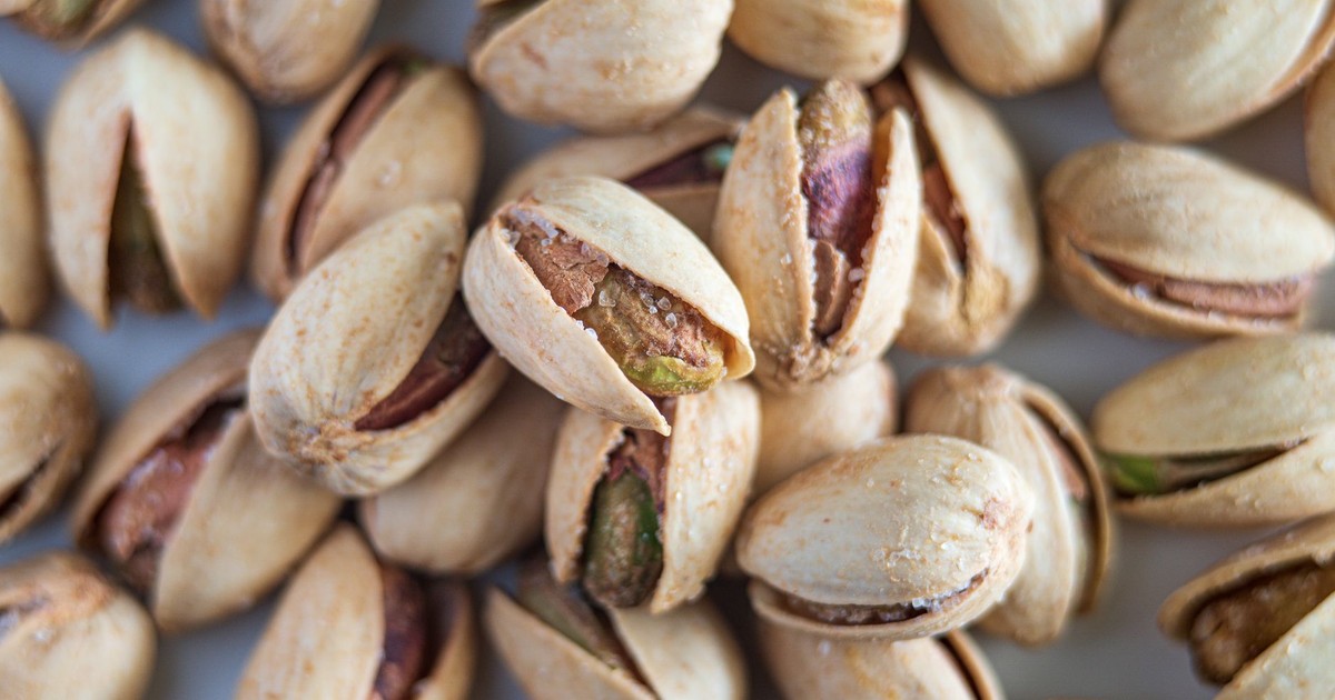 Macro photograph highlighting salted pistachios in their shells, showcasing detail and texture.