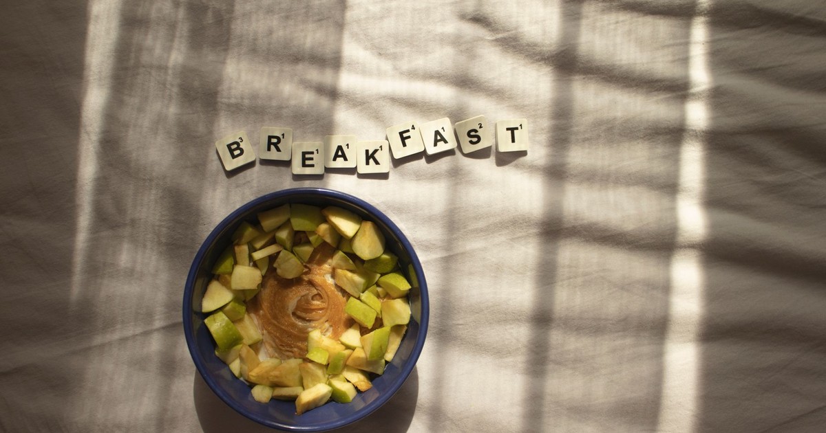 A nutritious breakfast bowl with peanut butter and apples in natural lighting.