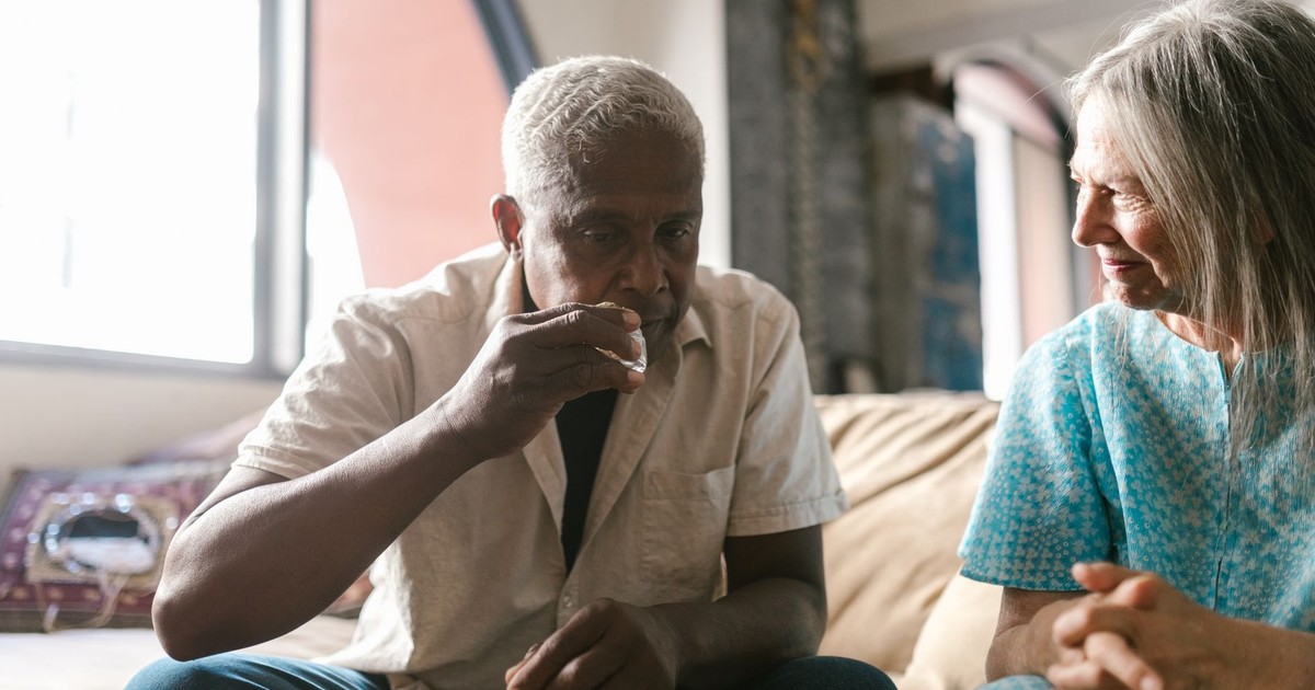 Elderly couple enjoying cannabis together in a cozy indoor setting.