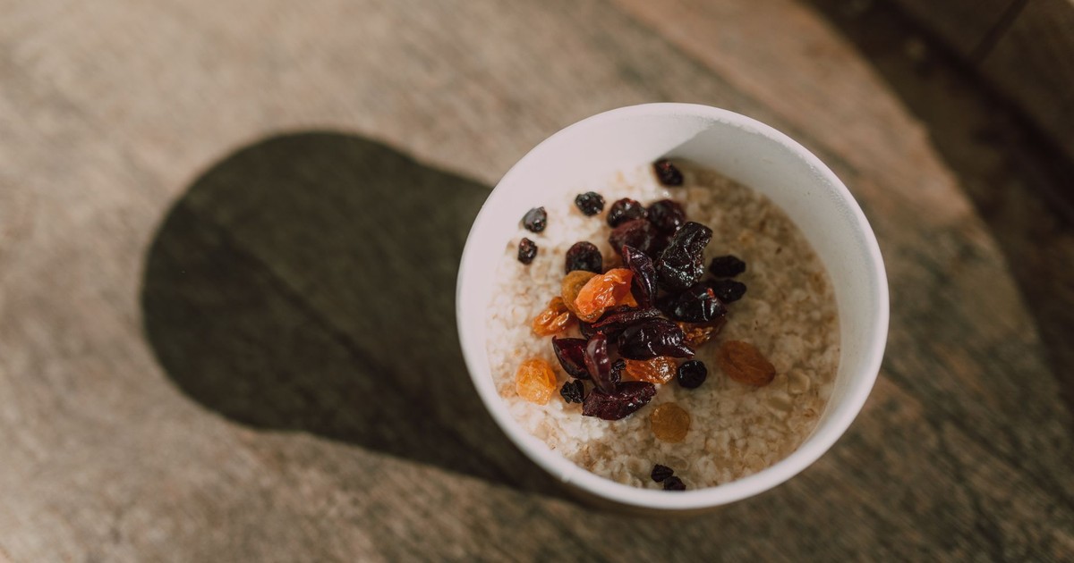 A nutritious bowl of oatmeal topped with a variety of dried fruits photographed from above.
