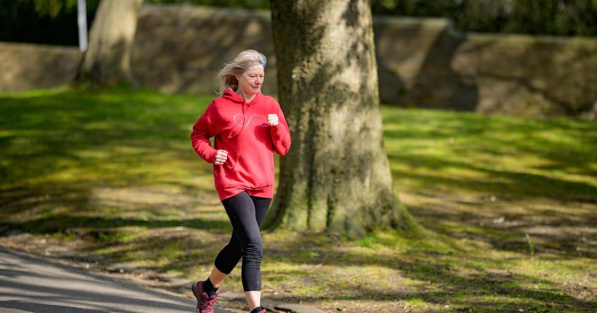 Elderly woman enjoying a healthy outdoor jog in a sunlit park.
