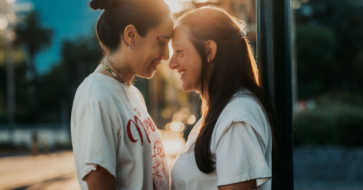 A loving couple shares a tender moment outdoors in Buenos Aires under warm sunlight.