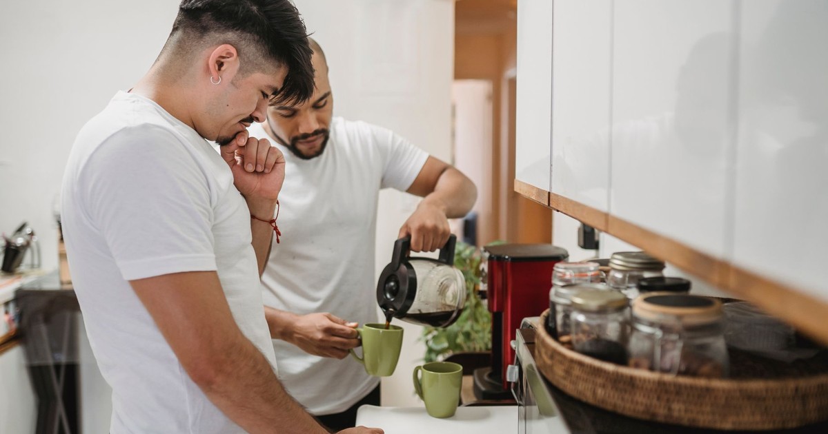 Two men in a kitchen pouring coffee into mugs, enjoying their morning ritual together.