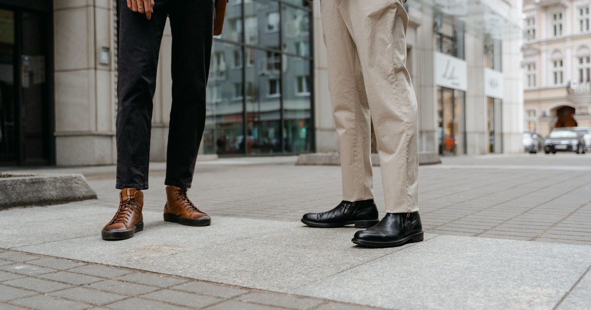 Stylish street fashion showcasing black and brown leather shoes on a city pavement.