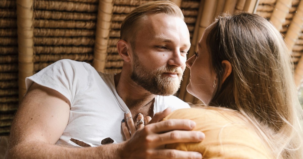 A couple affectionately looking into each other's eyes in a warm setting.