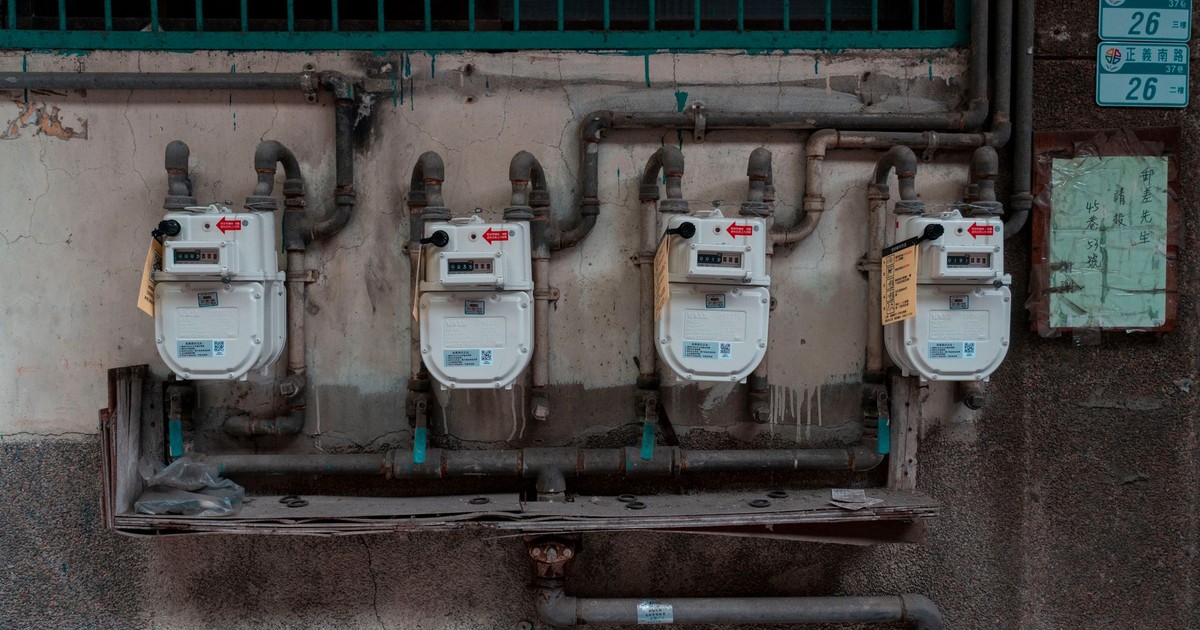 Four gas meters mounted on an exterior wall, showcasing urban utility infrastructure.