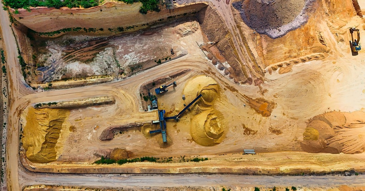 Aerial shot of a quarry with machinery extracting and processing materials.