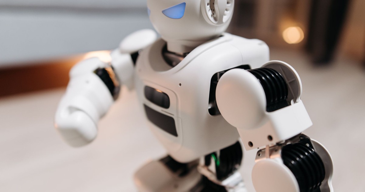Close-up of a futuristic toy robot with blue eyes, showcasing modern technology indoors.