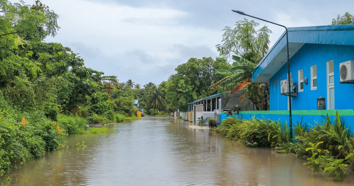 A tropical street in Nolhivaranfaru, Maldives, submerged due to flooding.