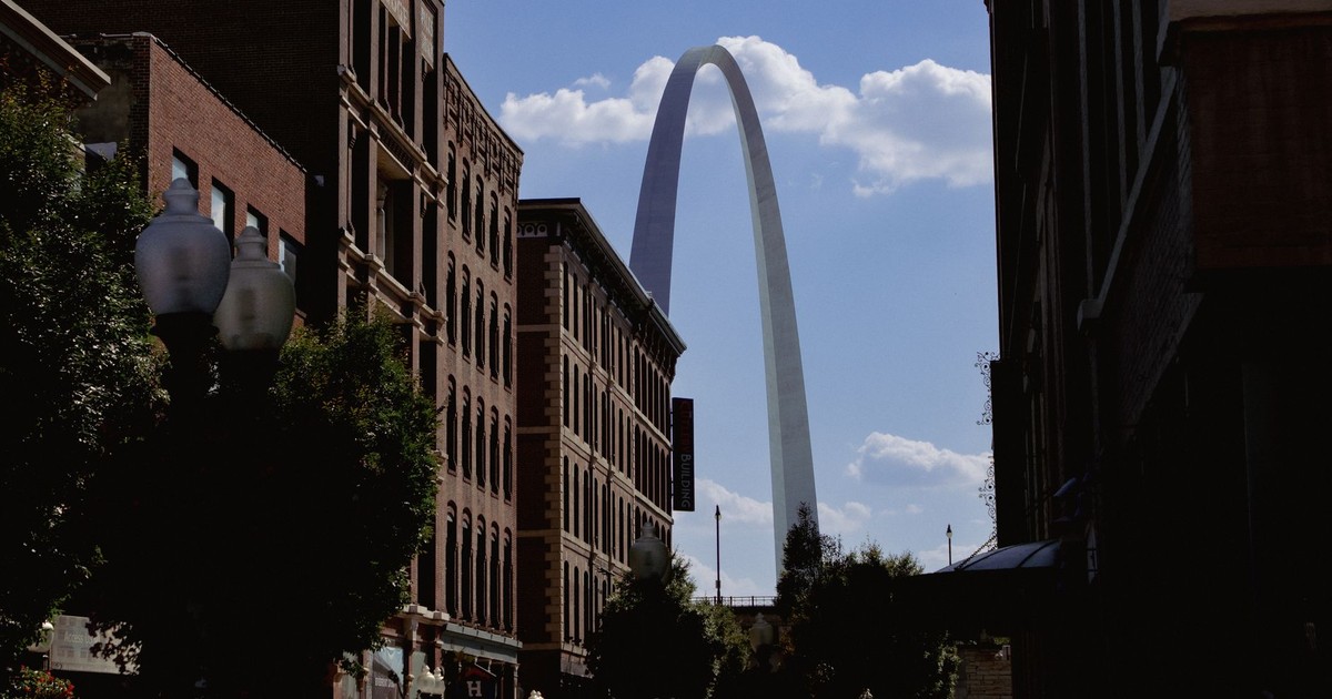 The iconic Gateway Arch rises between city buildings in St. Louis, USA.